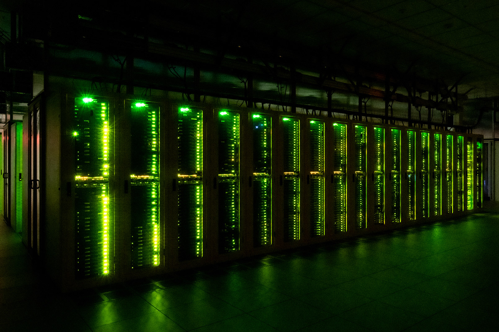 Interior at confidential client data center facility server room with green lights
