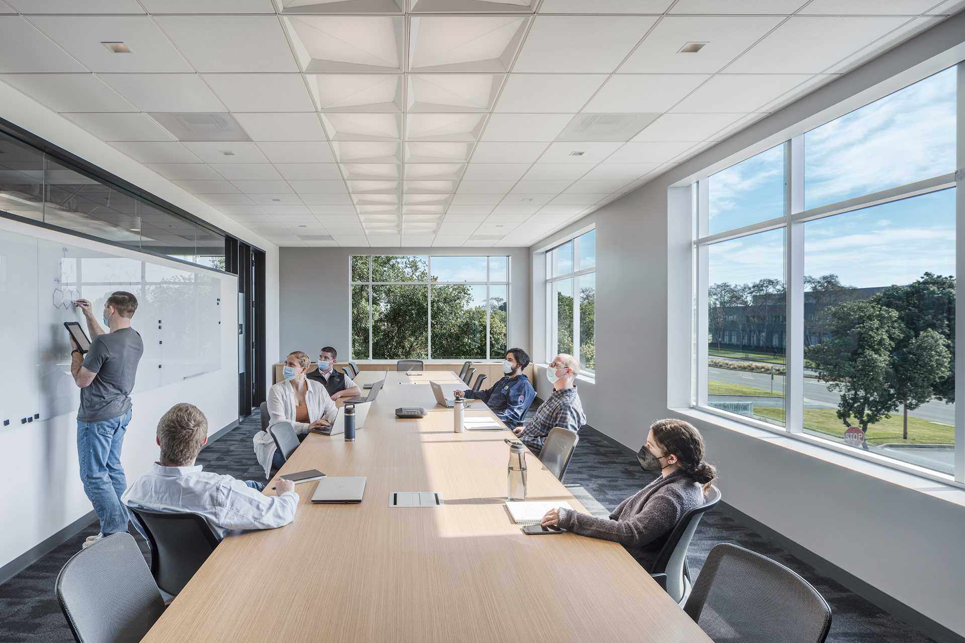 Interior at Exelixis 1701 HBP life science facility conference room with people meeting wearing masks