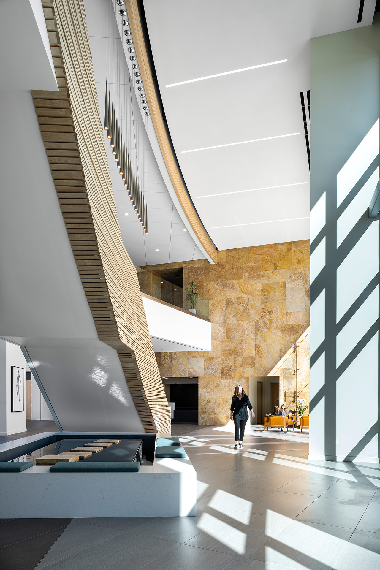 Interior at Ionis Conference Center lobby with view of water feature beneath the staircase