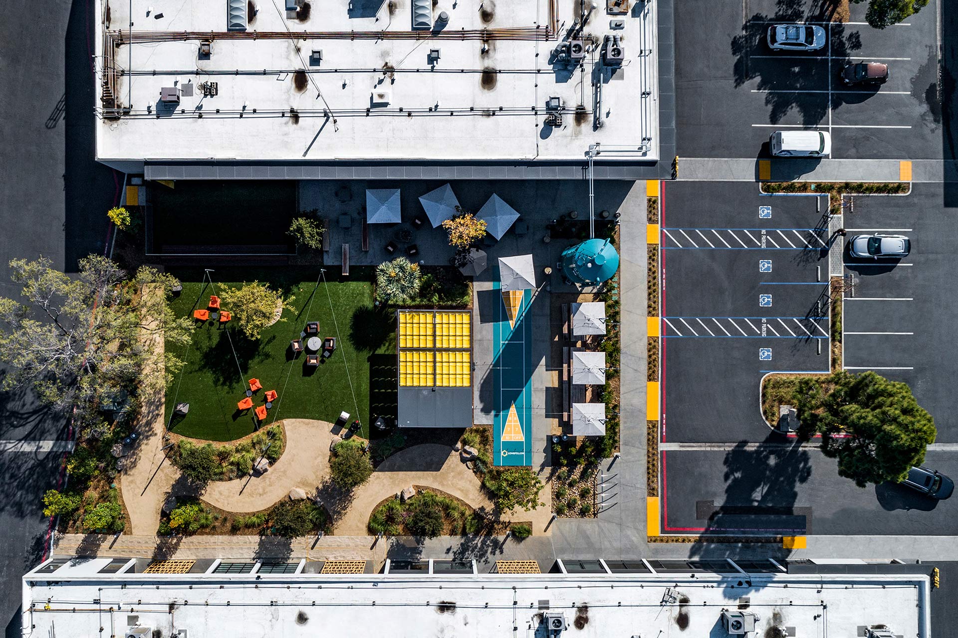 Exterior at Longfellow SOVA Science District life science facility, drone shot of outdoor amenity space, parking lot, and building