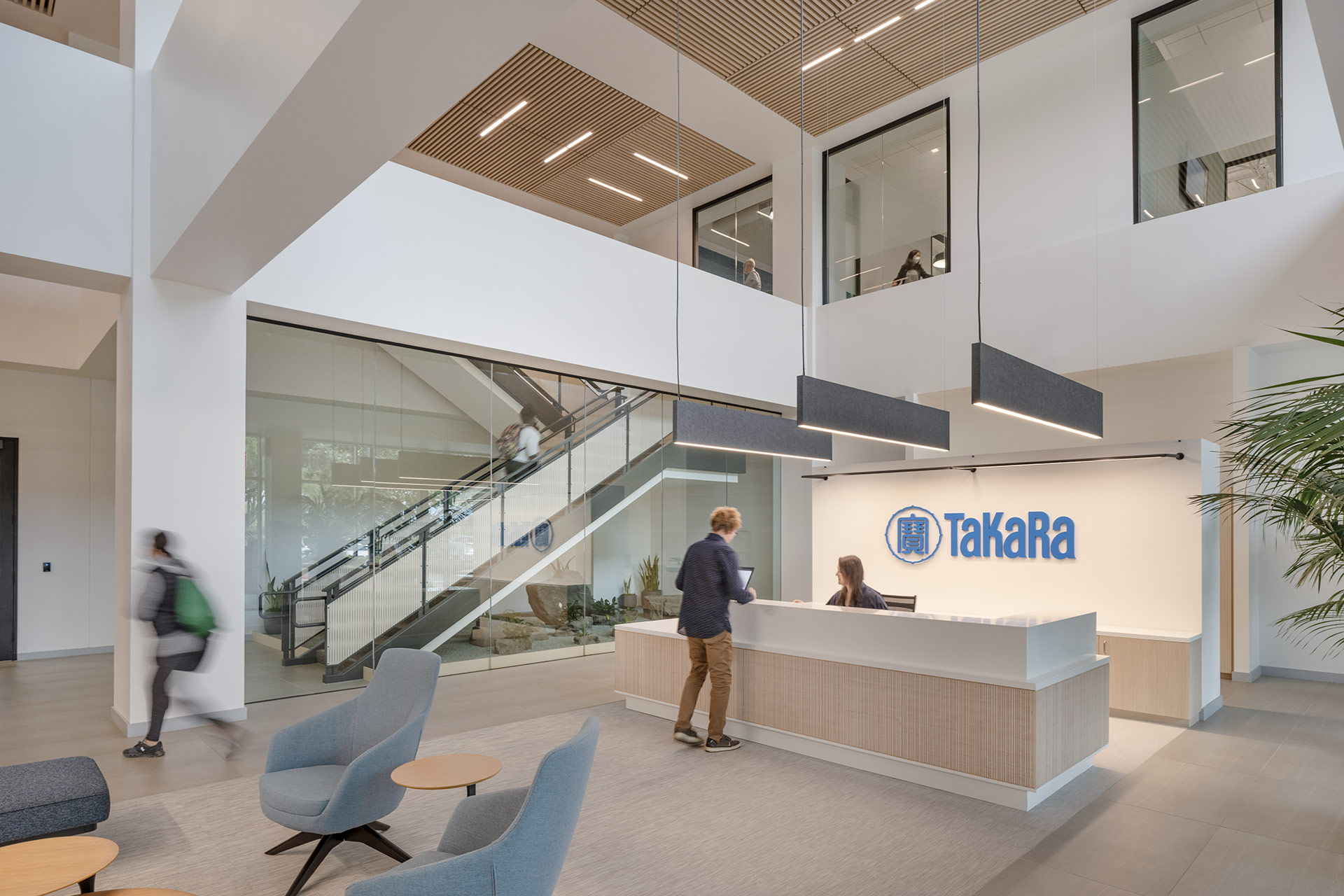 Interior at Takara Bio life science facility, lobby and front desk with stairway in the background