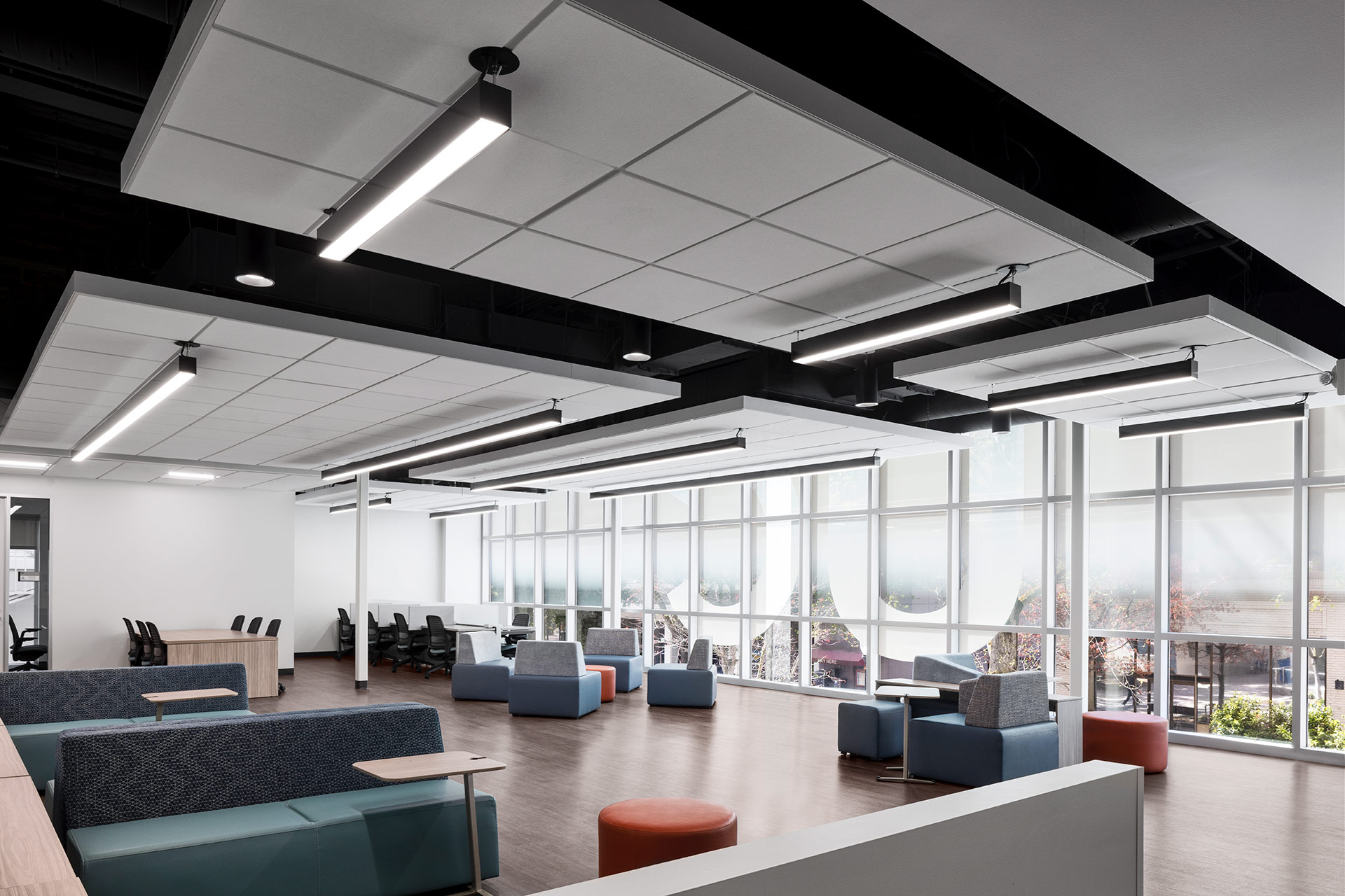 Interior at UC Center Sacramento academic facility, open work space with various places to sit and surfaces to work from or collaborate, view to city below outside