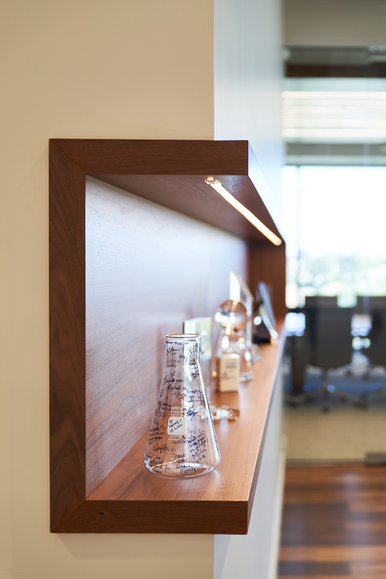 Interior at Vertex Pharmaceuticals life science facility, detail shot of shelving with scientific-related mementos