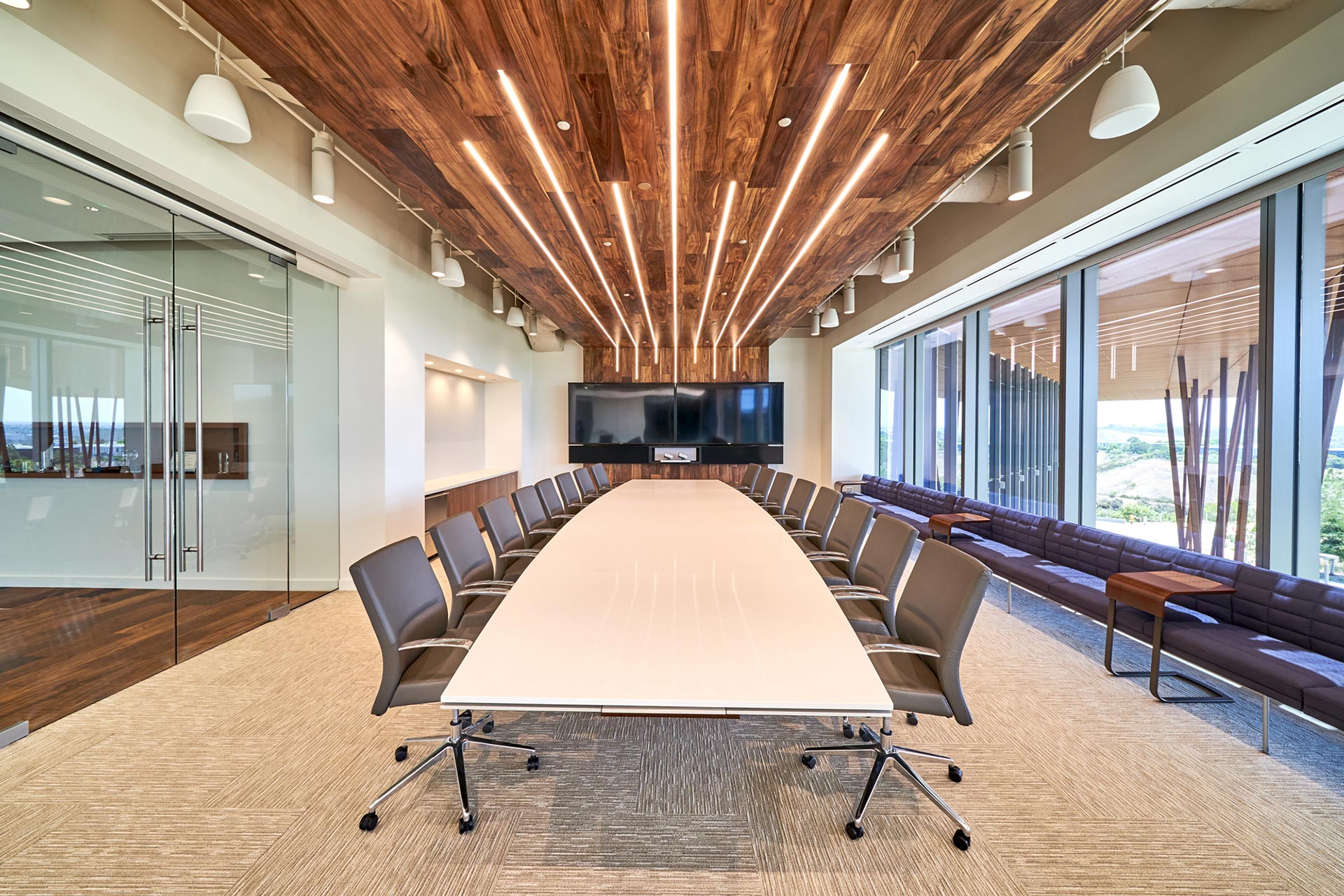 Interior at Vertex Pharmaceuticals life science facility, conference room with long conference table and screens